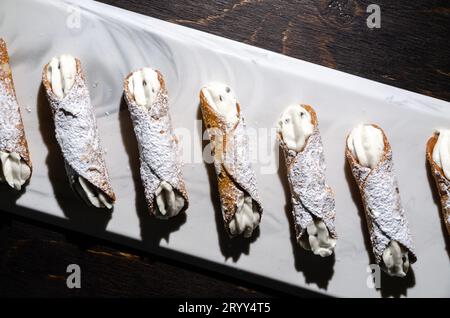 Photo de cannoli, desserts italiens originaires de Sicile. A une coquille dure remplie de ricotta et de pépites de chocolat, garnie de sucre glace. Banque D'Images