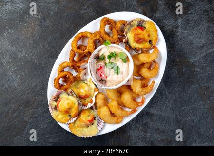 La nourriture péruvienne. Piqueo caliente. Fun pour plateau de fruits de mer crevettes frites, calamars cuits et anneaux de pétoncles avec sauce Banque D'Images