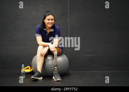 Jeune femme avec une jambe prothétique avec la pratique de l'utilisation de jambes prothétiques pour marcher, faire de l'exercice et et les activités quotidiennes Banque D'Images