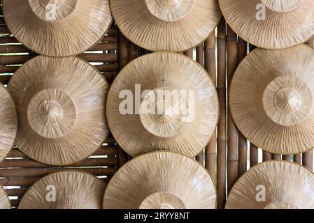 Plusieurs chapeaux de paille de fermiers ont été accrochés sur un mur en bambou. Objet et culture indigène de la Thaïlande concept. Banque D'Images