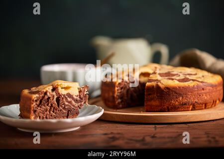 Tarte zèbre chocolat et vanille avec morceau coupé sur plaque. Gâteau au chocolat en marbre fait maison Banque D'Images