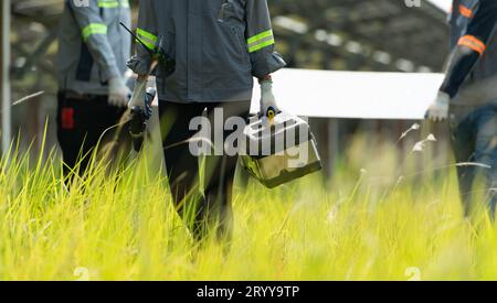 Ingénieurs et techniciens déchargeant des panneaux solaires réparés à installer sur les rangées de cellules solaires alignées sur des centaines de A. Banque D'Images