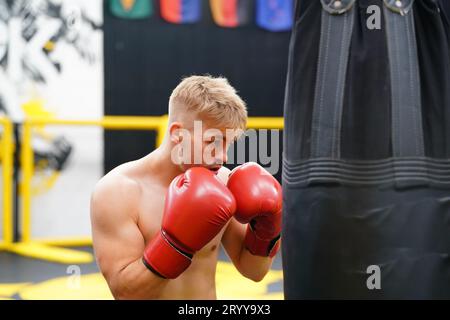 Muay Thai, l'art martial de la Thaïlande, Boxer pratiquant le poinçonnage avec sac de poinçonnage pour construire des coups de poing et des muscles puissants. Banque D'Images
