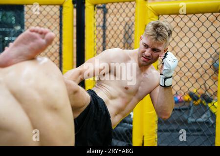 Art martial mixte, Un boxeur avec l'arme de coup de pied le cou la gorge de l'adversaire. Banque D'Images