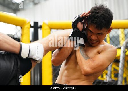 Art martial mixte, Un boxeur avec l'arme de coup de pied le cou la gorge de l'adversaire. Banque D'Images