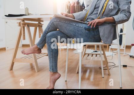 Dessinateur de mode féminin asiatique attrayant travaillant dans l'atelier de bureau à domicile. Femme fashionista élégante créant une nouvelle conception de tissu co Banque D'Images