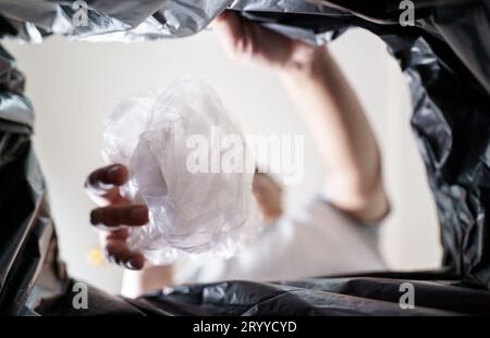 Image de l'intérieur du sac de recyclage jaune d'un homme jetant une bouteille en plastique vide dans un bac de recyclage Home recycle éco vert zéro concept Banque D'Images