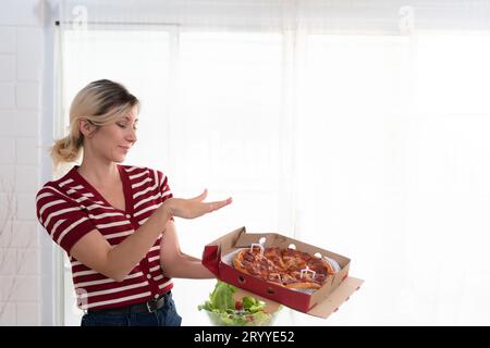 Jeune femme pense que la pizza est un aliment qui a très peu d'avantages nutritionnels. Au contraire, il est nocif pour la santé dans le Banque D'Images