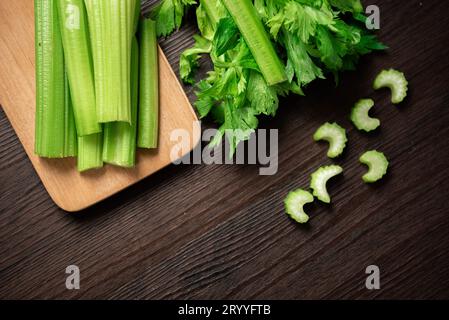 Vue de dessus de bouquet de branche de céleri tranché frais sur une table en bois avec des feuilles. Nourriture et ingrédients de légumes sains. Freshnes Banque D'Images