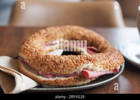 Un bagel à la tomate et au salami sur la table Banque D'Images