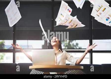 Femme d'affaires asiatique jetant de la paperasse dans l'air. Concept de réussite et de réalisation. Concept d'entreprise et d'occupation. Freela Banque D'Images