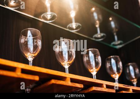 Étagère de verres à vin à boire dans le restaurant avec fond de vitrine d'éclairage. Beaucoup de conteneurs propres dans le restaurant ou le pub de nuit an Banque D'Images