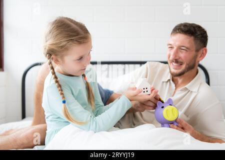 Père enseigne à sa fille comment économiser de l'argent afin que l'enfant ait les compétences pour gérer l'argent et vivre Banque D'Images