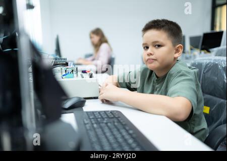 Les jeunes utilisant la technologie de robot de main s'amusent à apprendre la carte de circuit électronique et le contrôleur de robot de main de Banque D'Images