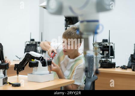 Les jeunes utilisant la technologie de robot de main s'amusent à apprendre le contrôleur de robot de main de la technologie de robot, qui est o Banque D'Images