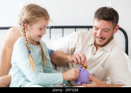 Père enseigne à sa fille comment économiser de l'argent afin que l'enfant ait les compétences pour gérer l'argent et vivre Banque D'Images