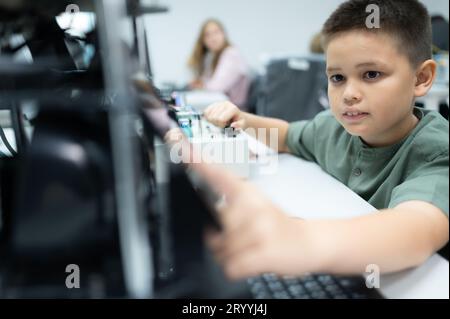 Les jeunes utilisant la technologie de robot de main s'amusent à apprendre la carte de circuit électronique et le contrôleur de robot de main de Banque D'Images