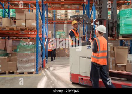 Les gestionnaires, les contremaîtres et les travailleurs de l'entrepôt se consultent pour sortir les marchandises de l'entrepôt afin de terminer l'envoi du smal Banque D'Images