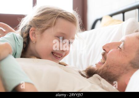 Un père aime parler avec sa fille dans sa chambre. avant de dire au revoir et d'envoyer sa fille au lit Banque D'Images