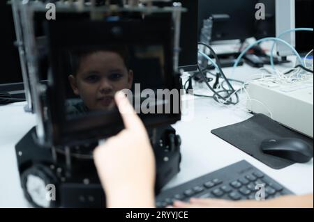 Les jeunes utilisant la technologie de robot de main s'amusent à apprendre la carte de circuit électronique et le contrôleur de robot de main de Banque D'Images