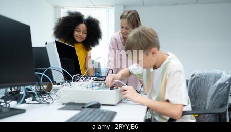 Les jeunes utilisant la technologie de robot de main s'amusent à apprendre la carte de circuit électronique et le contrôleur de robot de main de Banque D'Images