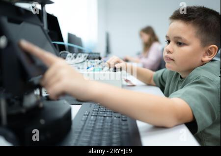 Les jeunes utilisant la technologie de robot de main s'amusent à apprendre la carte de circuit électronique et le contrôleur de robot de main de Banque D'Images