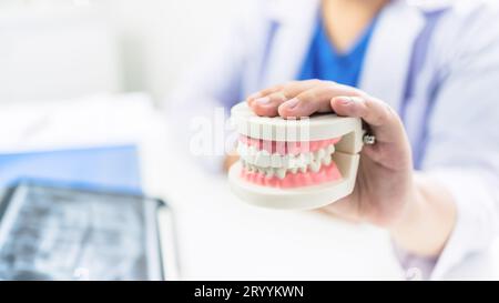 Dentiste à la clinique dentaire dent blanche en bonne santé avec modèle dentaire chez les chirurgiens buccaux discutant de la radiographie de mâchoire sur tabletÂ Medicine healc Banque D'Images