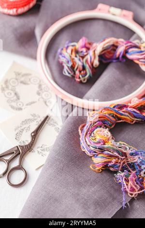 Ensemble de broderie. Tissu de lin, motifs de broderie, cerceau de broderie, fils colorés et aiguilles. Banque D'Images