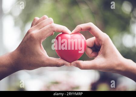 Couple dans l'amour faisant la forme de symbole de coeur avec le doigt et les mains ensemble. Concept de Saint Valentin. Voyage romantique et nous Banque D'Images