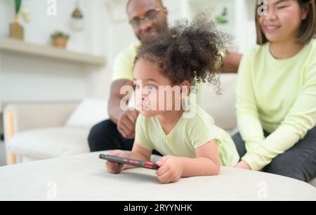 Les petits enfants jouent et apprennent des choses dans le monde entier sur tablette. avec les parents pour superviser et aider dans le salon de la Banque D'Images