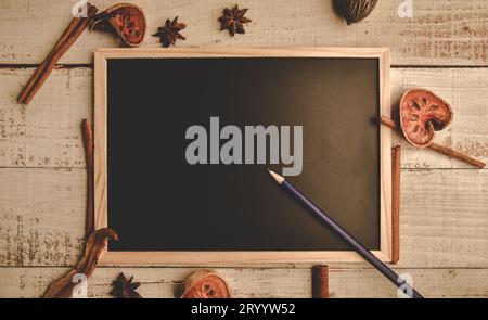 Tableau noir en bois vide de l'école sur plancher en bois avec un crayon et des feuilles sèches. Education et concept nature. Thème de retour à l'école. T Banque D'Images