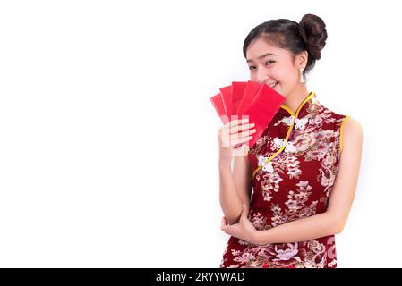 Jeune femme de beauté asiatique portant cheongsam et tenant le paquet d'argent geste dans le festival chinois nouvel an événement sur isolé W Banque D'Images