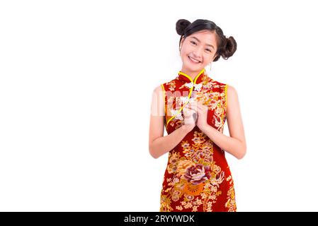 Jeune femme de beauté asiatique portant cheongsam et geste de bénédiction ou de salutation dans l'événement du festival du nouvel an chinois sur blanc isolé Banque D'Images