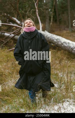 Une jeune femme marche à travers une forêt hivernale en Lettonie, Pavilosta Banque D'Images