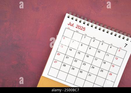 Calendrier de bureau de juillet 2025 sur fond de couleur rouge. Banque D'Images