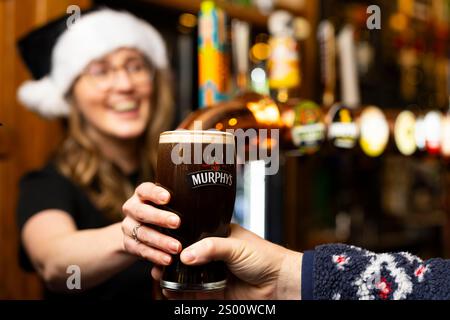 UTILISATION ÉDITORIALE SEULE Une pinte de Murphy's Irish Stout est versée après avoir été livrée par Heineken UK à un pub de Londres en réaction aux pénuries de Guinness signalées ce Noël. Date de la photo : lundi 23 décembre 2024. Banque D'Images