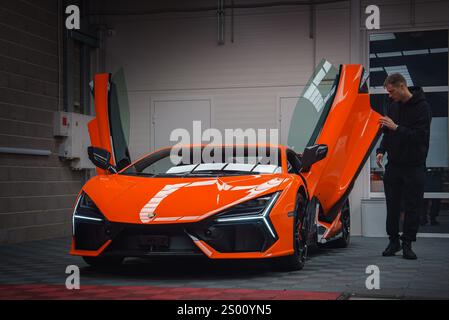 Orange Lamborghini Revuelto avec portes en ciseaux ouvertes dans la salle d'exposition Banque D'Images