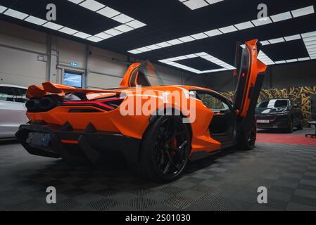 Orange Lamborghini Revuelto avec portes ciseaux ouvertes à l'intérieur Banque D'Images