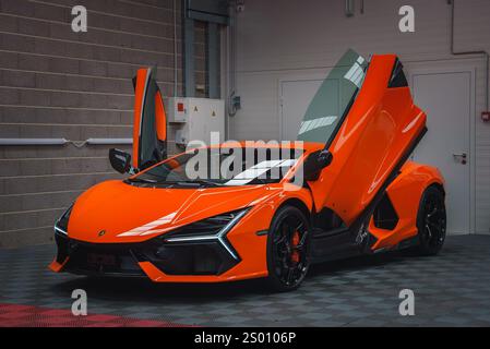 Orange Lamborghini Revuelto avec portes ciseaux ouvertes à l'intérieur Banque D'Images