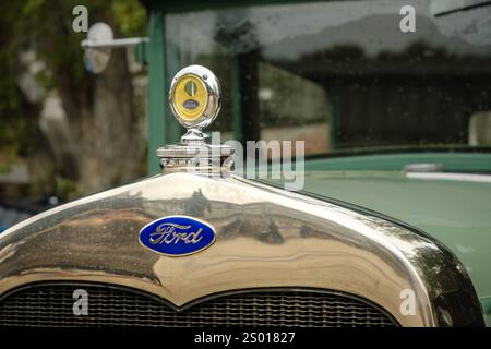 Lisbonne, Portugal - 15 octobre 2023 : gros plan et focus sélectif sur le Boyce MotoMeter sur le dessus du capot ou du capot et l'emblème Ford et la plaque de logo sur la calandre, Ford modèle A. Banque D'Images