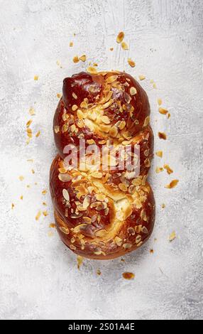 Tarte au pain tressé, sucré, avec des amandes tranchées, petit déjeuner, pain tressé, brioche, sur un fond clair, vue de dessus, pas de gens Banque D'Images