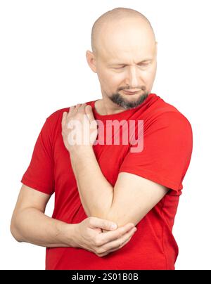 Un homme portant un T-shirt rouge est représenté tenant son coude et son épaule, exprimant douleur et inconfort. Banque D'Images