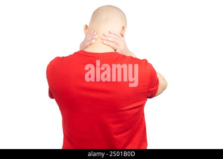 Un homme portant un T-shirt rouge est représenté par le dos, tenant son cou avec les deux mains, exprimant douleur et inconfort. Banque D'Images