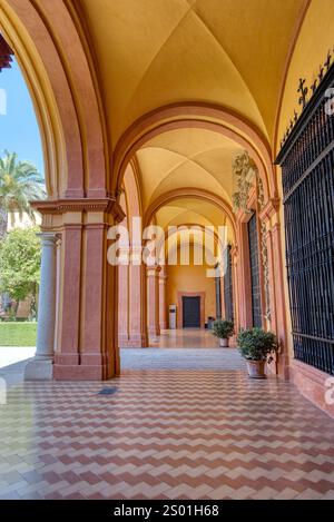 Séville, Espagne - 1er septembre 2023 : colonnes arquées en marbre ornées et cour dans l'Alcazar royal de Séville masque islamique Banque D'Images