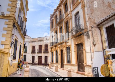 De vieux bâtiments bordent la rue pavée du village de Ronda, en Espagne Banque D'Images