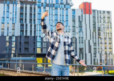 Homme d'âge moyen touriste essayant d'attraper un signal de communication et Internet sur le téléphone mobile, a soulevé le téléphone pour une meilleure connexion dans la rue du centre-ville. Un caucasien frustré en ville. Banque D'Images
