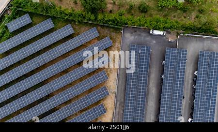 Cette perspective aérienne révèle un vaste réseau de panneaux solaires dans une installation commerciale, mettant en évidence l'adoption de ressources énergétiques renouvelables dans un an Banque D'Images