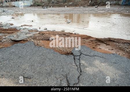 Conséquences des inondations en Espagne et des glissements de terrain. Route détruite au bord du lit de la rivière suite à des inondations extrêmes à Paiporta Banque D'Images