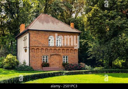 Porto, Pologne - 17 août 2024 : Maison suisse rénovée du complexe médiéval gothique du château d'Oporowskich dans le parc historique du village d'Oporow Banque D'Images