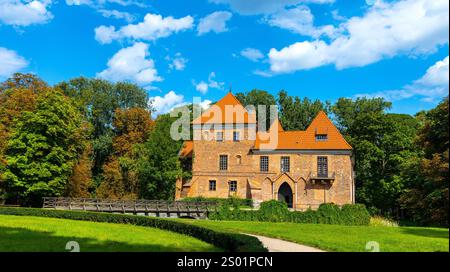 Oporow, Pologne - 17 août 2024 : chevaliers médiévaux gothique en brique château d'Oporowskich avec fossés humides et pont-levis dans le parc historique du village d'Oporow Banque D'Images